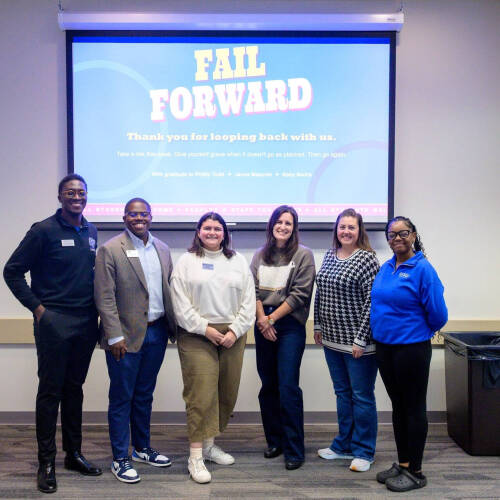 six people standing in front of screen that reads Fail Forward